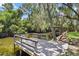 Wooden dock extending over calm water with lush greenery at 12270 Virginia Dr, Leesburg, FL 34788