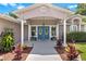 Welcoming entryway with teal double doors and lush landscaping at 12270 Virginia Dr, Leesburg, FL 34788
