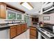 Kitchen features wood cabinets, stainless steel appliances, and a view to the backyard at 12270 Virginia Dr, Leesburg, FL 34788