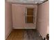 A room with a window and damaged walls and flooring needing renovations at 1605 Rose Ln, Eustis, FL 32726