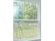 View of backyard through window, showing green grass and trees at 2368 Juniper Berry Dr, Minneola, FL 34715