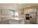 Modern kitchen with white cabinets, quartz countertops, and stainless steel appliances at 2368 Juniper Berry Dr, Minneola, FL 34715