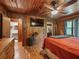 Cozy bedroom with wood walls, ceiling fan, and en-suite bathroom at 2027 Cr 232, Wildwood, FL 34785
