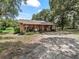 House exterior showcasing a wooden home with a large yard at 2027 Cr 232, Wildwood, FL 34785