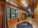 Long hallway with wood walls, a large window, and rustic wooden furniture at 2027 Cr 232, Wildwood, FL 34785