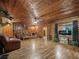 Rustic living room featuring hardwood floors, leather furniture, and log cabin walls at 2027 Cr 232, Wildwood, FL 34785