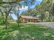 Wooden house exterior surrounded by lush trees at 2027 Cr 232, Wildwood, FL 34785