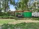 Green storage shed with covered parking for ATV at 2027 Cr 232, Wildwood, FL 34785
