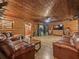 Living room with log cabin walls, hardwood floors, and comfortable leather furniture at 2027 Cr 232, Wildwood, FL 34785