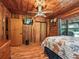 Bedroom with wood walls, ceiling fan, and en-suite bathroom at 2027 Cr 232, Wildwood, FL 34785