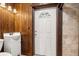 Small bathroom with wood-paneled walls, a toilet, and a pedestal sink at 1113 Oakland Cir, Tavares, FL 32778