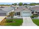 Tan house with white picket fence, attached garage, and driveway; aerial view at 2809 Burgos Dr, The Villages, FL 32162