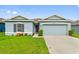 One-story home with light blue exterior, two-car garage, and landscaping at 1163 Haines Dr, Winter Haven, FL 33881