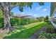 Landscaped backyard with lush greenery, a large tree, and a privacy hedge at 3914 Scarborough Ct, Clermont, FL 34711