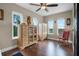 Bedroom with hardwood floors, multiple windows, and a rocking chair at 13910 Max Hooks Rd, Clermont, FL 34711