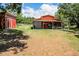 Red barn with covered parking and additional storage shed at 13910 Max Hooks Rd, Clermont, FL 34711