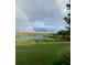 Rainbow over calm lake and grassy area at 13910 Max Hooks Rd, Clermont, FL 34711
