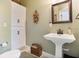 Elegant bathroom with pedestal sink, white toilet, and white cabinets at 13910 Max Hooks Rd, Clermont, FL 34711