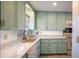 Charming kitchen with light teal cabinets and granite countertops at 601 N Mcdonald St # 608, Mount Dora, FL 32757