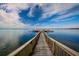 Long wooden pier extending over calm water, leading to a small building in the distance at 601 N Mcdonald St # 608, Mount Dora, FL 32757