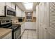 Galley kitchen with microwave, oven and white cabinets at 601 N Mcdonald St # 608, Mount Dora, FL 32757