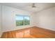 Hardwood floor bedroom with large window and a ceiling fan at 601 N Mcdonald St # 608, Mount Dora, FL 32757