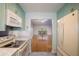 Kitchen view showcasing light teal cabinets and hardwood floors at 601 N Mcdonald St # 608, Mount Dora, FL 32757