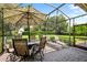 Relaxing screened patio with paver stones, outdoor furniture, and lush landscaping at 8692 Crested Eagle Pl, Sanford, FL 32771