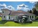 Home's back exterior showcasing a screened patio and well-manicured yard at 8692 Crested Eagle Pl, Sanford, FL 32771