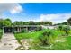 Single-story home with covered porch and palm trees at 34035 Linda Ln, Leesburg, FL 34788