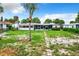 Large backyard with overgrown grass and screened porch at 34035 Linda Ln, Leesburg, FL 34788