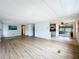 Open living room with wood-look floors and view into kitchen at 34035 Linda Ln, Leesburg, FL 34788