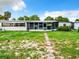 Backyard with overgrown grass and screened porch at 34035 Linda Ln, Leesburg, FL 34788