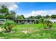 Single-story home with covered porch and tropical landscaping at 34035 Linda Ln, Leesburg, FL 34788