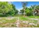 Overgrown backyard with stone pathway leading to home at 34035 Linda Ln, Leesburg, FL 34788
