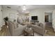 Living room with wood-look floors, staged furniture, and a TV at 131 Costa Mesa Dr, The Villages, FL 32159