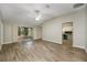 Spacious living room with wood-look floors and access to a screened patio at 131 Costa Mesa Dr, The Villages, FL 32159