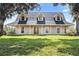 Two-story home with gray roof and neutral siding, featuring a covered porch at 31050 State Road 44, Eustis, FL 32736