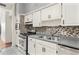 Kitchen boasts white cabinets, stainless steel appliances, and tile backsplash at 6919 Fern Cir, Leesburg, FL 34748