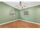 Well-lit bedroom featuring wood floors and two windows at 6919 Fern Cir, Leesburg, FL 34748
