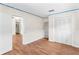 Bedroom with wood floors, built-in shelving, and access to another room at 6919 Fern Cir, Leesburg, FL 34748