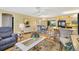 Open-concept living area with hardwood floors, stylish furniture, and kitchen views at 8084 Se 175Th Malmaison St, The Villages, FL 32162