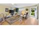 Bright living room with hardwood floors, comfortable furniture, and large TV at 8084 Se 175Th Malmaison St, The Villages, FL 32162