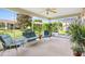 Relaxing screened porch with seating area, ceiling fan, and lush greenery at 8084 Se 175Th Malmaison St, The Villages, FL 32162