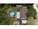 Aerial view showing house, pool, sheds and lush landscaping at 14700 Se 94Th Ave, Summerfield, FL 34491
