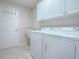 Laundry room with washer, dryer, and storage cabinets at 2410 Little Mountain Loop, The Villages, FL 32162