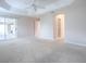 Large main bedroom with plush carpeting and access to the private bathroom and backyard at 2410 Little Mountain Loop, The Villages, FL 32162