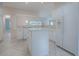White kitchen features an island, stainless steel appliances, and tile floors at 2410 Little Mountain Loop, The Villages, FL 32162