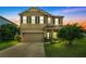 Two-story house with a neutral color scheme and a three-car garage at 278 Blue Cypress Dr, Groveland, FL 34736