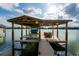 Covered boat dock with lift and seating area at 2537 E Crooked Lake Dr, Eustis, FL 32726